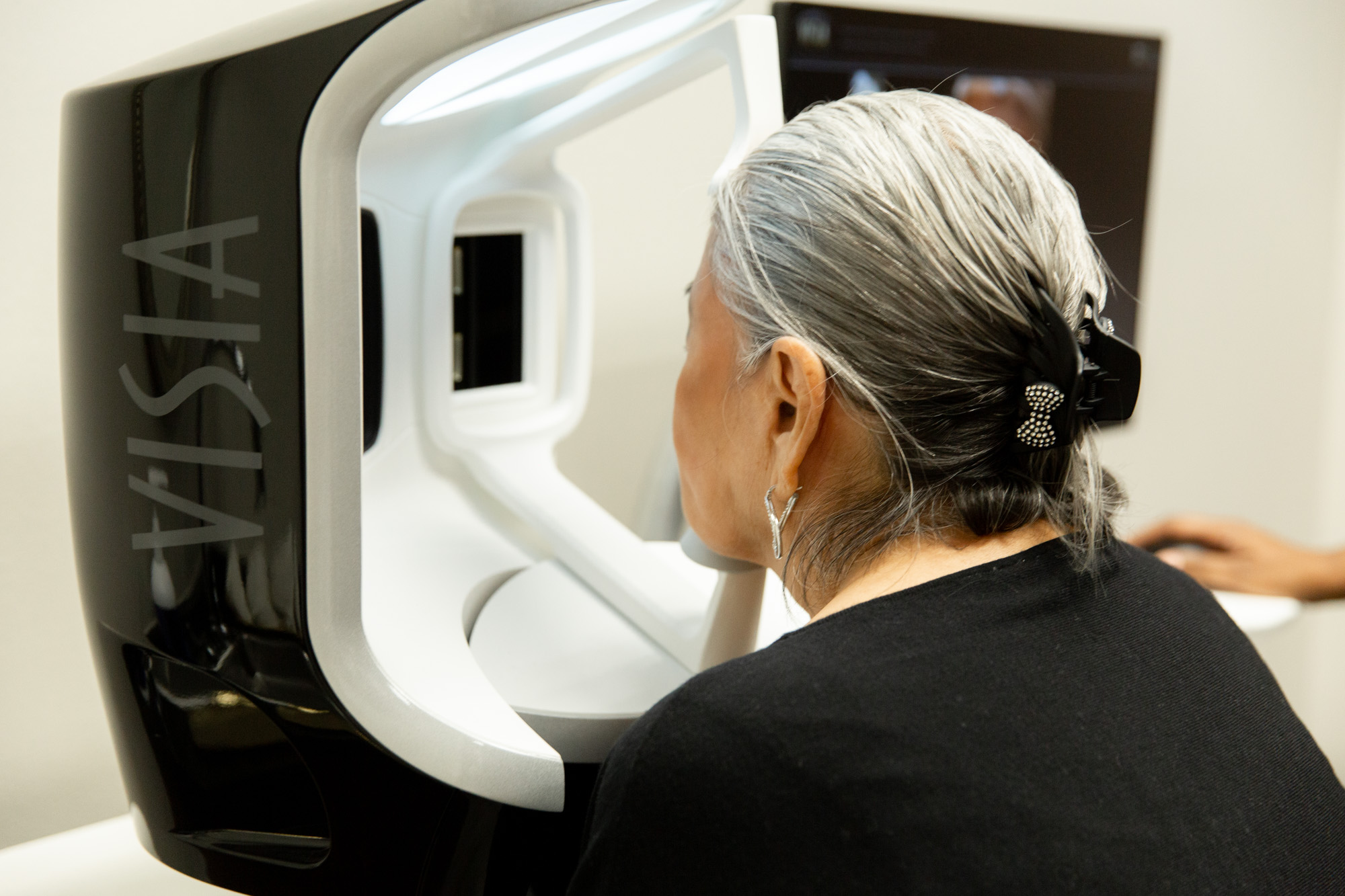 A female client looks into the Visia machine, waiting for treatment to begin.