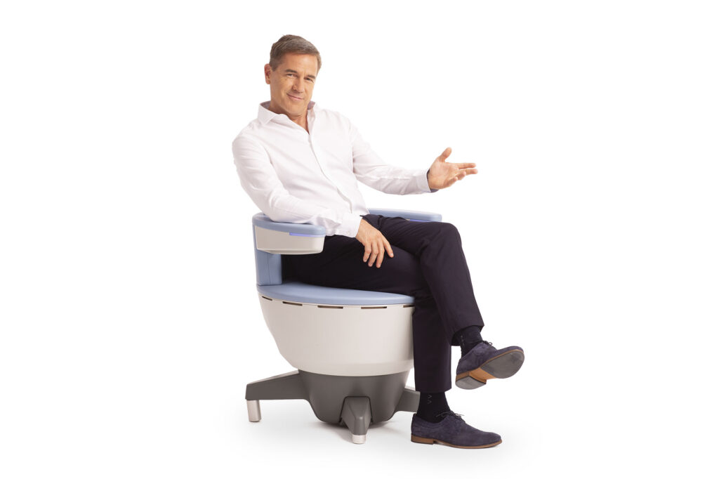 Well-dressed man sits on the Emsella chair for erectile dysfunction treatment in San Antonio.