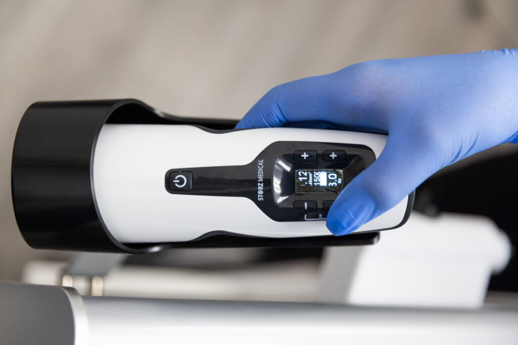 A provider changing the settings on a Storz Shockwave Therapy device for erectile dysfunction treatment in San Antonio.